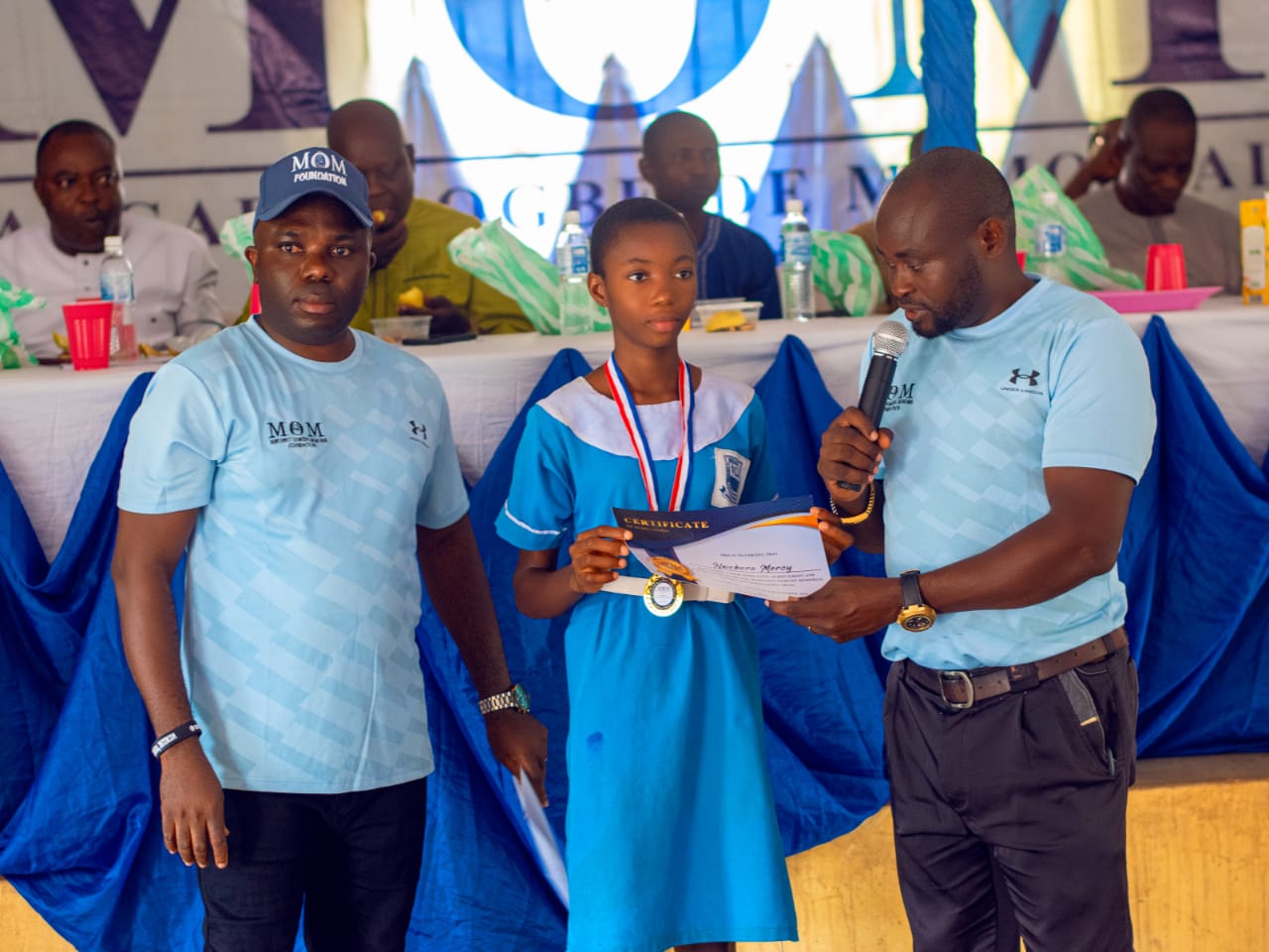 An awardee being presented with certificate of excellence by the Project Manager.